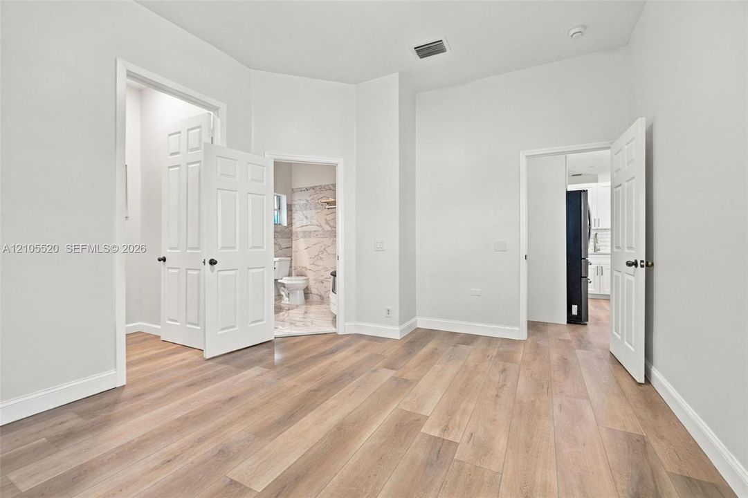 Interior space featuring wood-finish flooring, high ceilings, and multi-panel interior doors