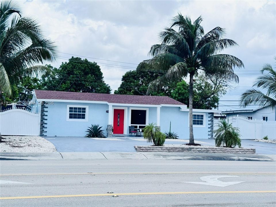 Light blue exterior with white trim windows and a red entry door