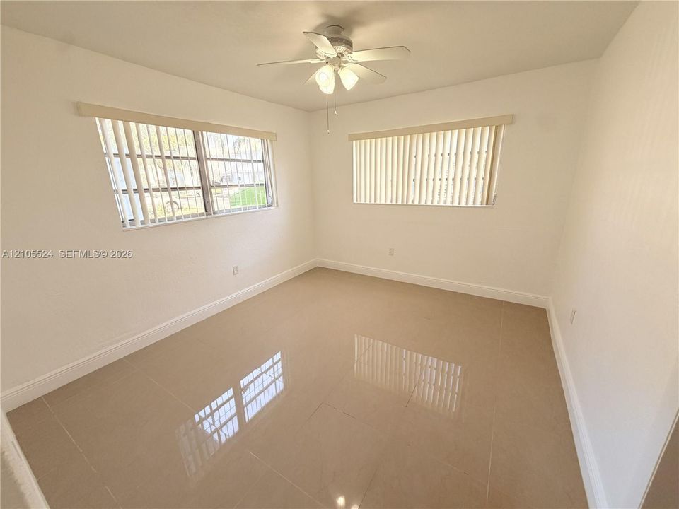Recessed lighting, ceiling fan, two windows, and tile flooring