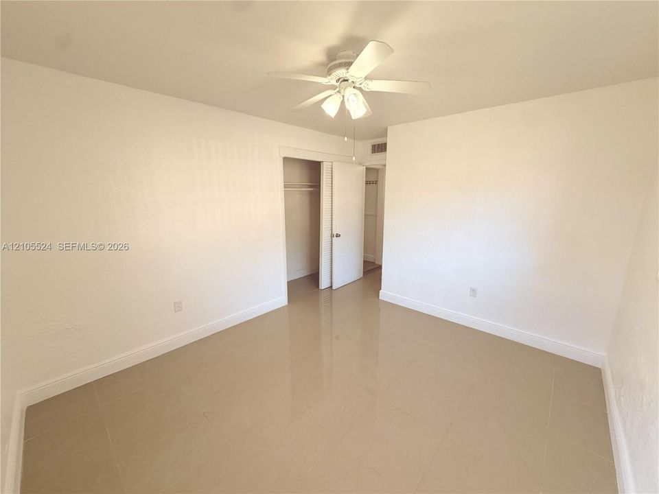 Neutral tone wall finish with recessed lighting and a ceiling fan