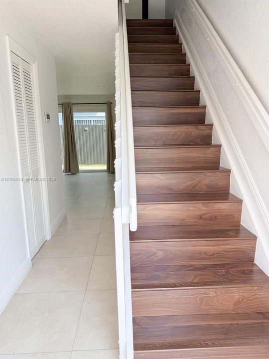 Wood-finish staircase with white risers and railing