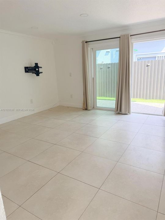 Recessed lighting, crown molding, and large-format tile flooring