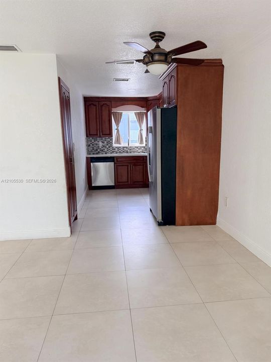 Kitchen area with wood-finish cabinetry, stainless steel appliances, and a mosaic tile backsplash