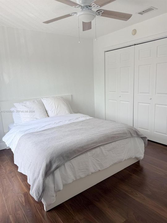 Wood-finish flooring, ceiling fan with light fixture, and bi-fold closet doors