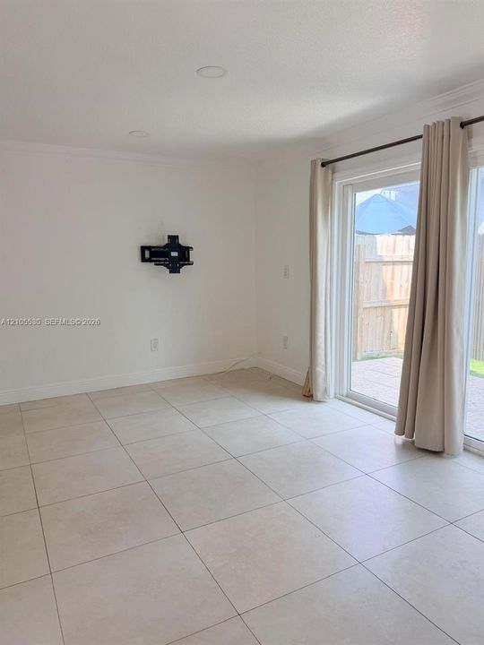 Recessed lighting, light-toned tile flooring, and sliding glass doors to exterior