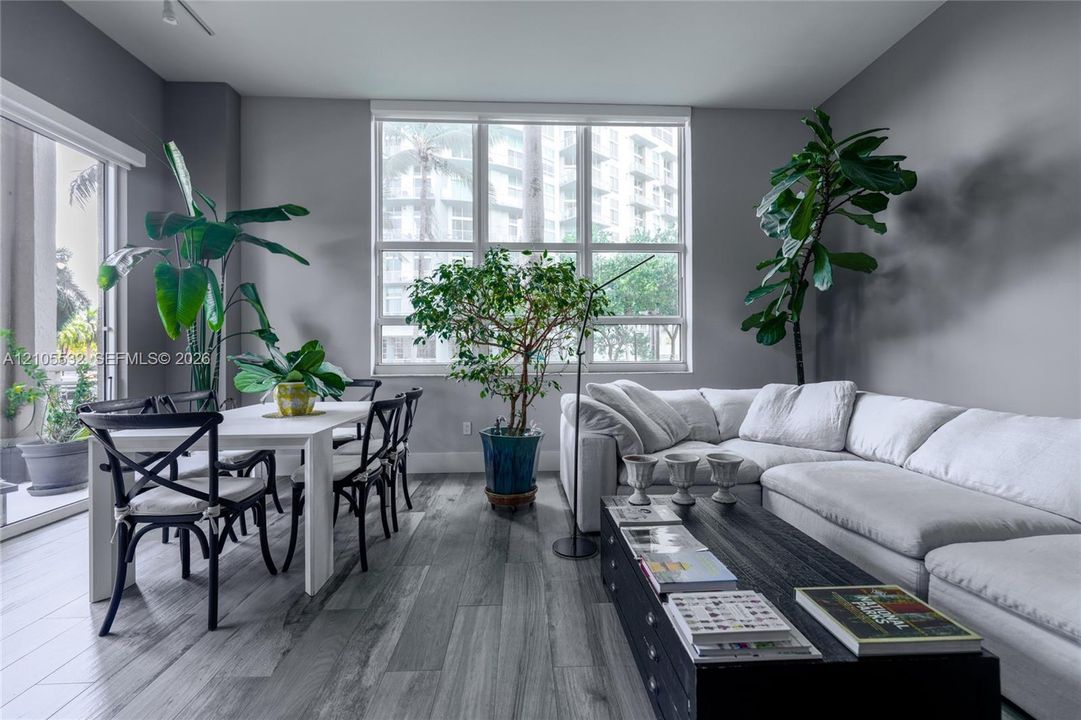 Living area featuring wood-finish flooring, floor-to-ceiling windows, and access to an exterior terrace