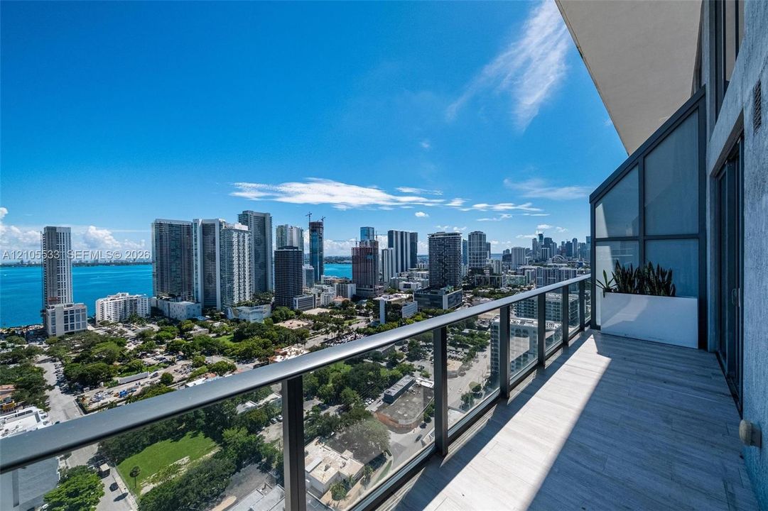 Private balcony featuring tile flooring and a glass panel railing