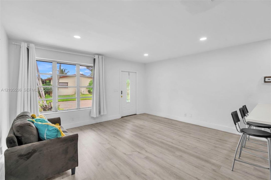 Open living area featuring wood-finish flooring, recessed lighting, and a multi-pane window with exterior exposure