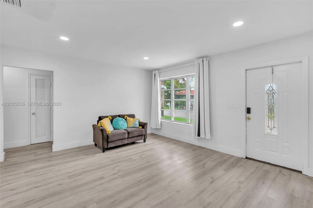 Interior space featuring wood-finish flooring, recessed lighting, multi-pane window, and an exterior door with decorative glass inlay