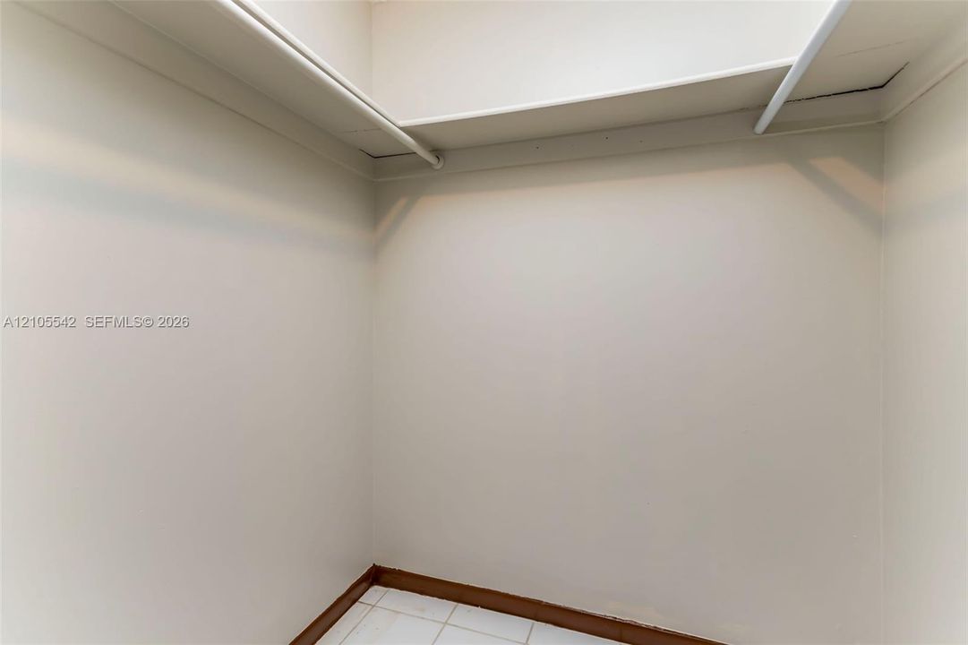 White walls with a single shelf and hanging rod