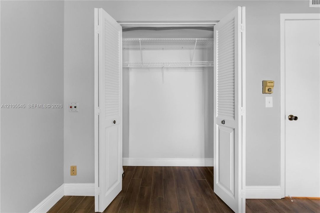 Louvered bi-fold closet doors revealing wire shelving
