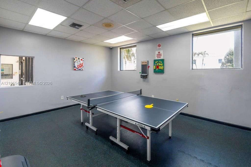 Recessed ceiling lights, acoustic ceiling tiles, two large windows, and resilient flooring