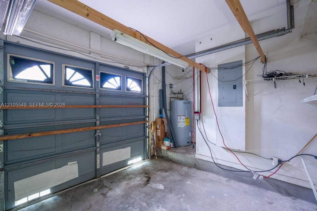 Garage space featuring a paneled door with transom windows, a utility sink, and a water heater