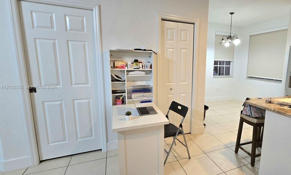 Tile flooring, solid-core interior doors, bifold closet doors, and a multi-arm overhead light fixture