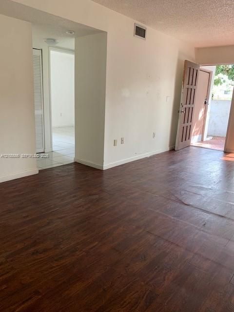 Dark wood-finish flooring provides a rich contrast to the light-colored walls