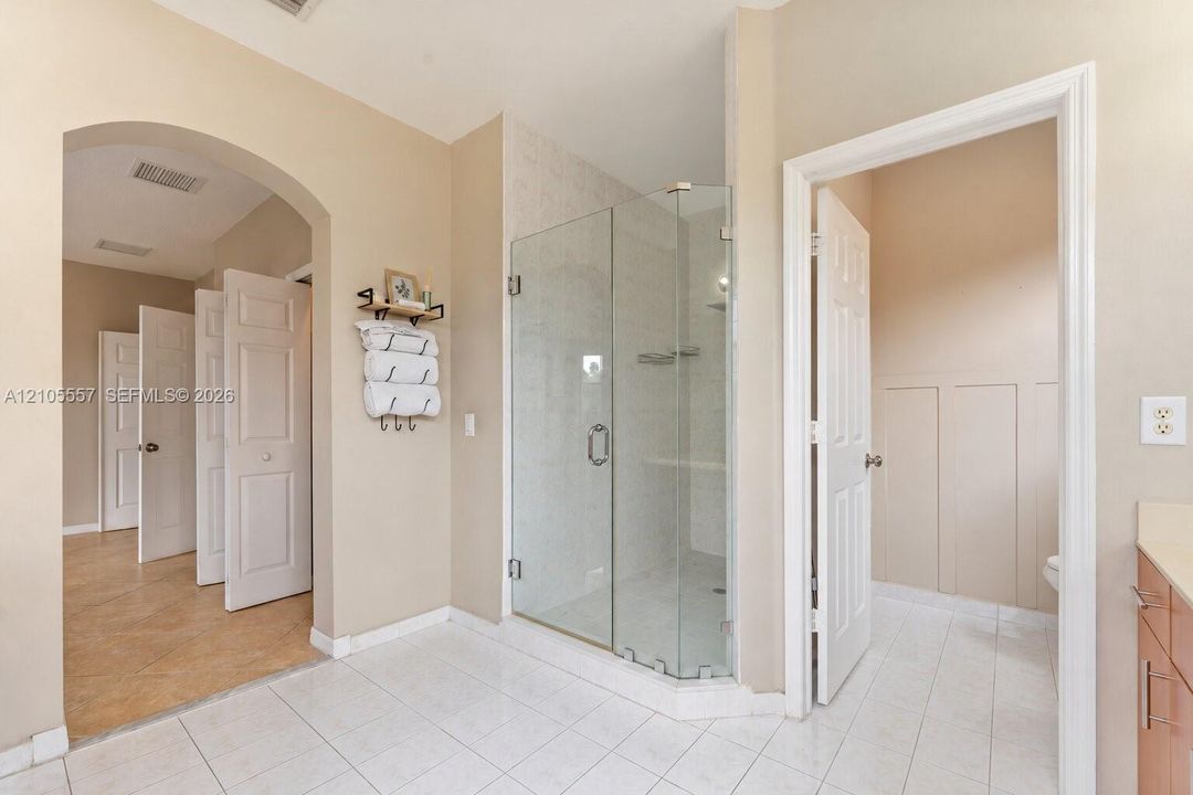 Enclosed glass shower with tiled interior and built-in shelving