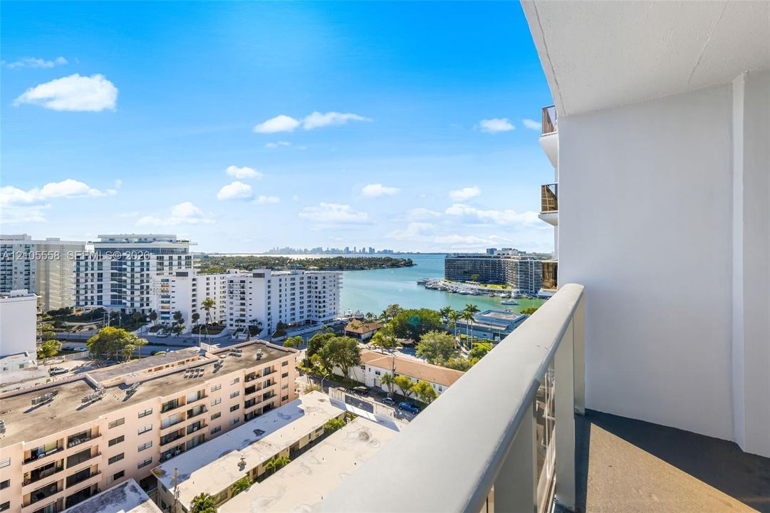Balcony featuring a partial water backdrop and urban skyline
