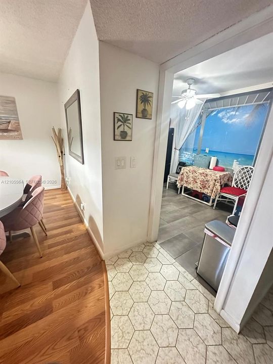 Wood-finish flooring, hexagonal tile flooring, and gray rectangular tile flooring create distinct zones