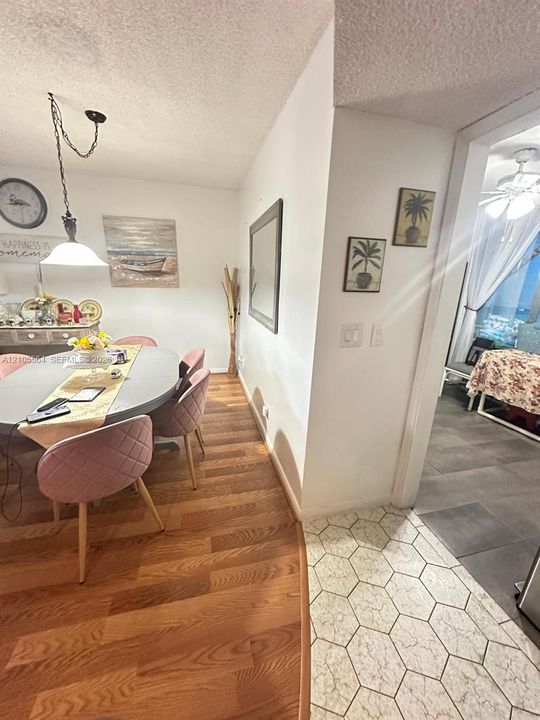 Wood-finish flooring, white walls, and a hanging pendant light fixture