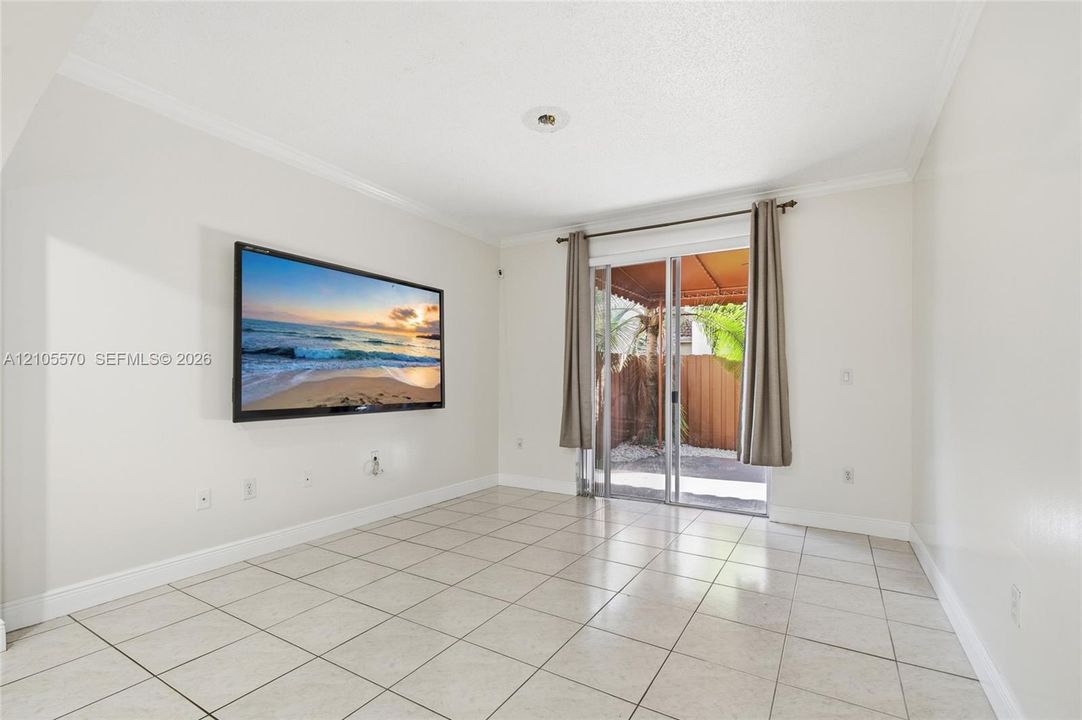 White tile flooring, sliding glass door, crown molding, recessed lighting, and a private outdoor area