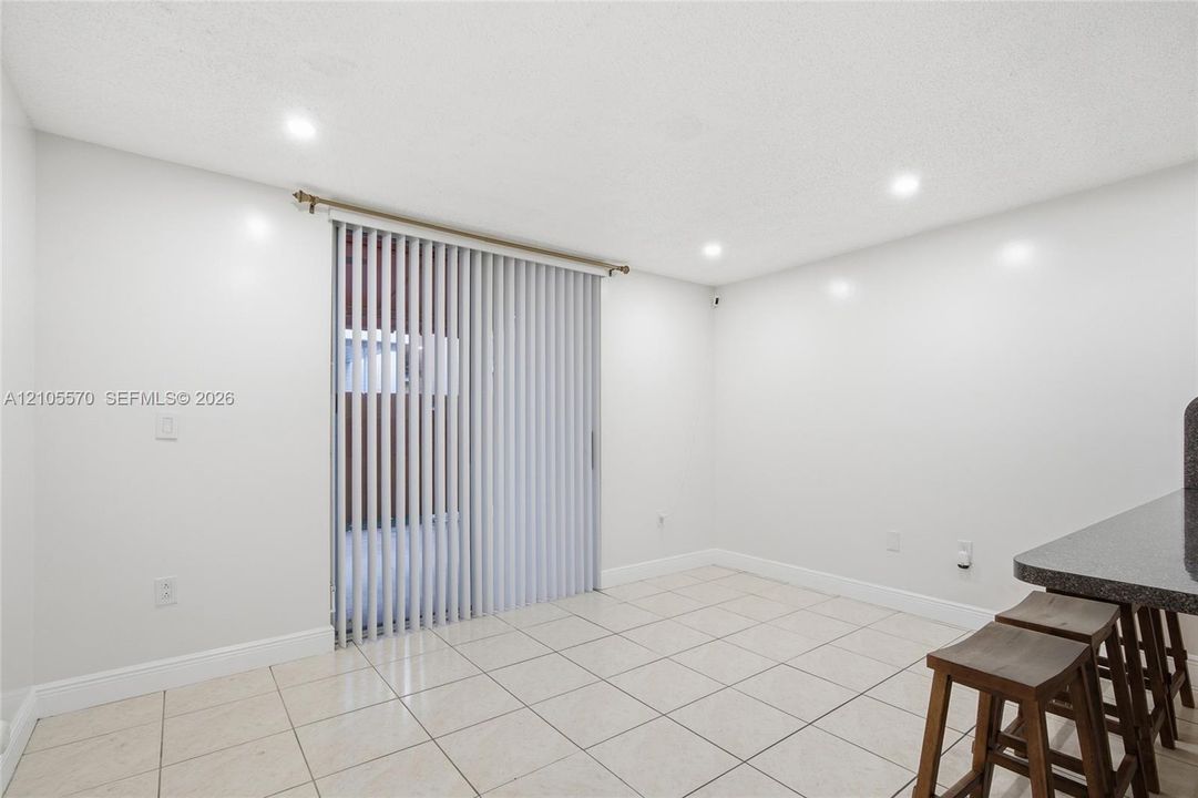 Tiled flooring and white walls with recessed lighting