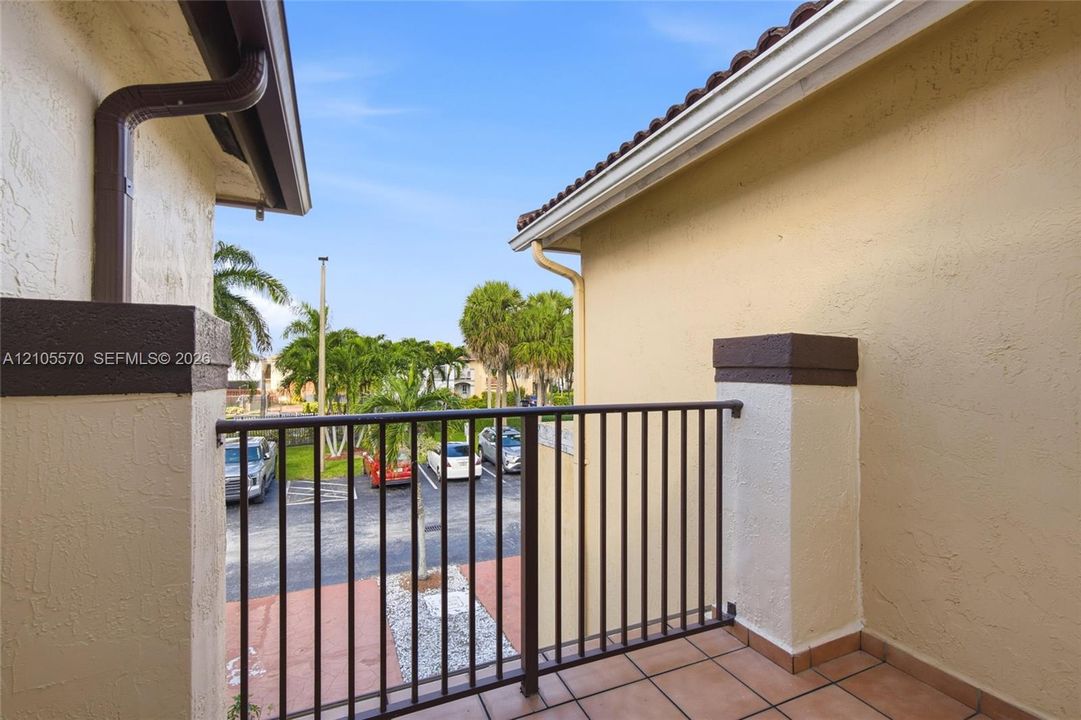 Balcony featuring tiled flooring and a wrought iron railing