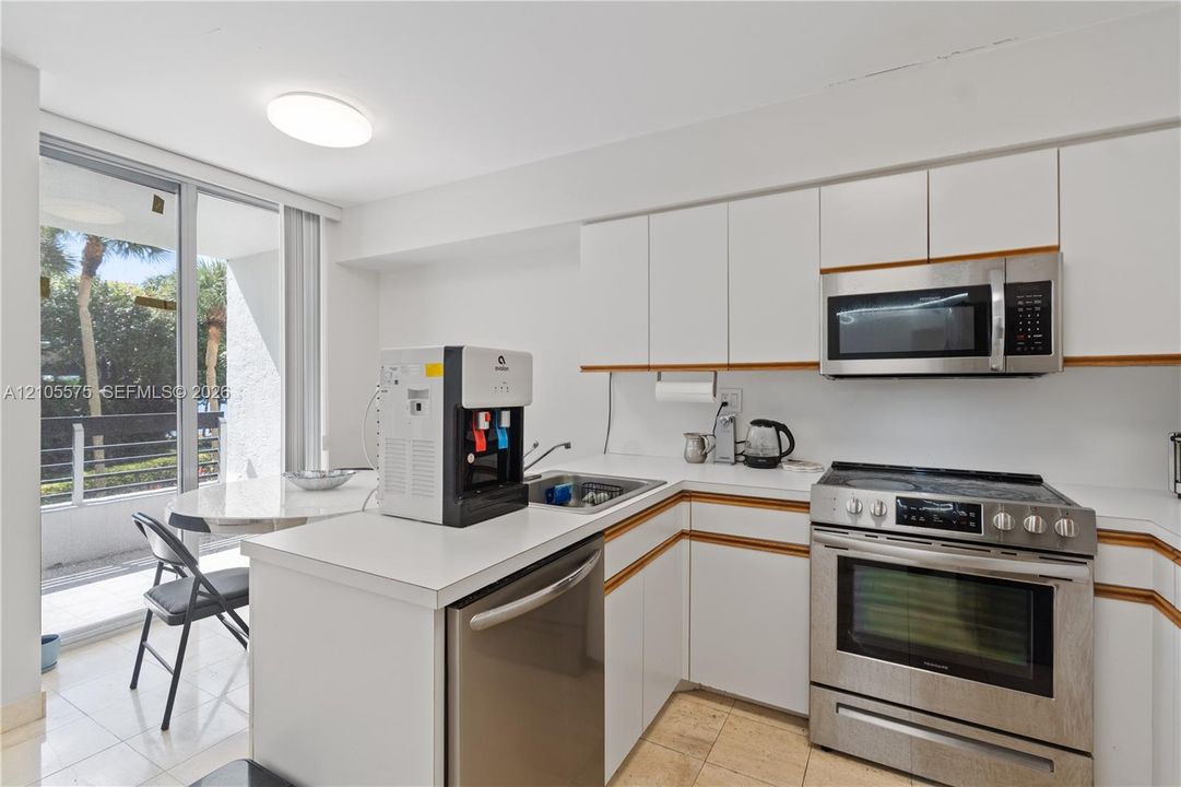 Functional kitchen featuring a convenient breakfast area and direct balcony access, offering a comfortable setting for everyday dining at Mystic Pointe in Aventura.