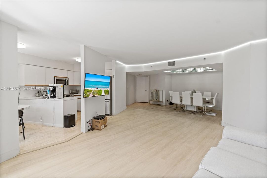 Spacious living room featuring an open-concept kitchen and direct access to a private balcony, creating a bright and inviting living space at Mystic Pointe in Aventura.
