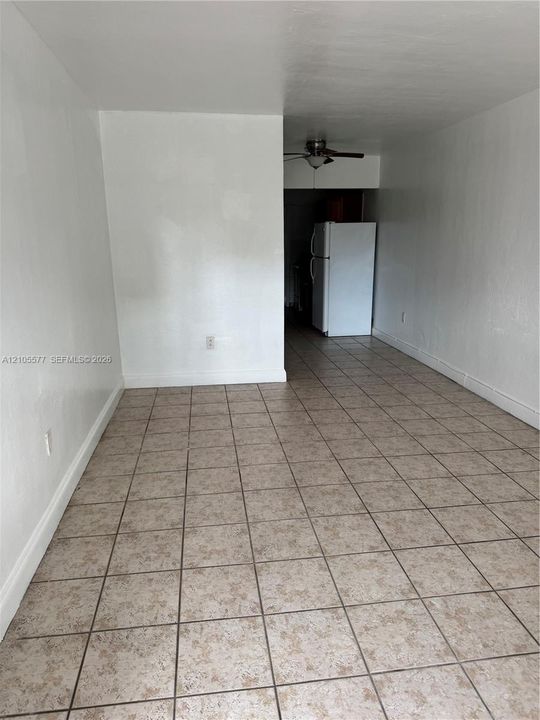 Ceramic tile flooring, neutral wall finishes, and a ceiling-mounted light fixture with fan