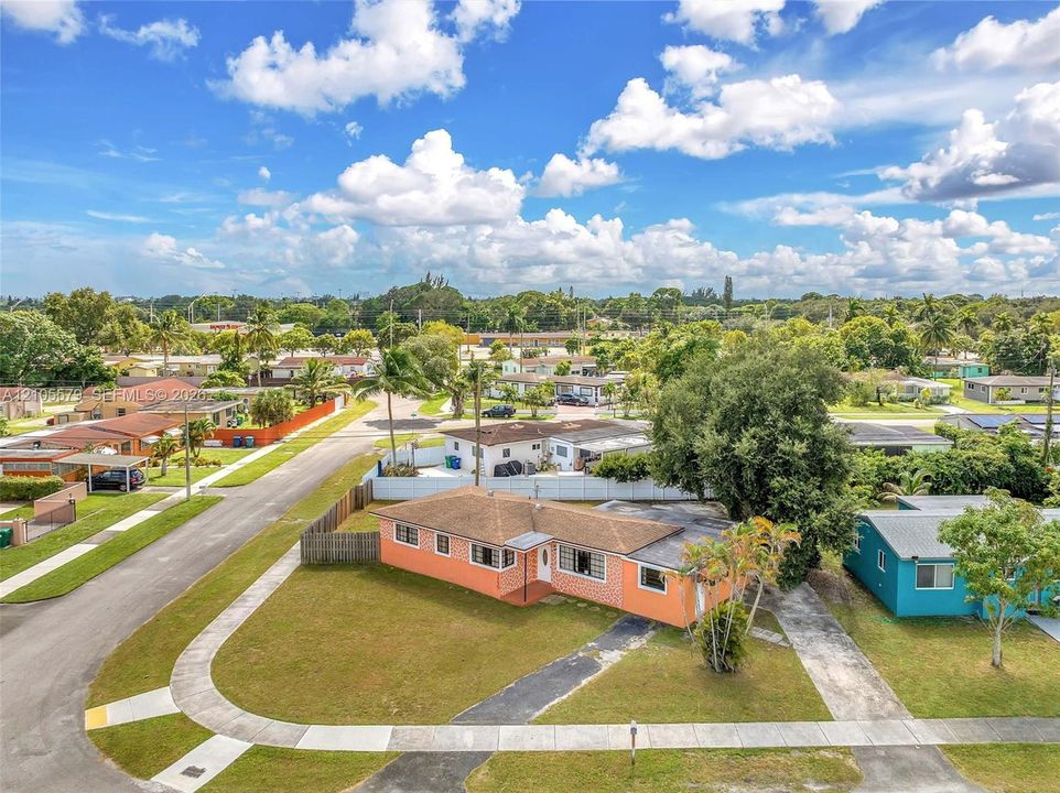 Single-story residence featuring a hipped roof, brick-veneer exterior, concrete driveway, and mature landscaping