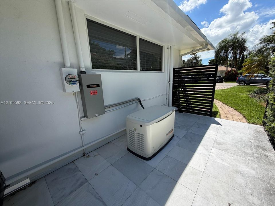 Exterior wall with a Generac standby generator, a service meter, and a primary electrical panel