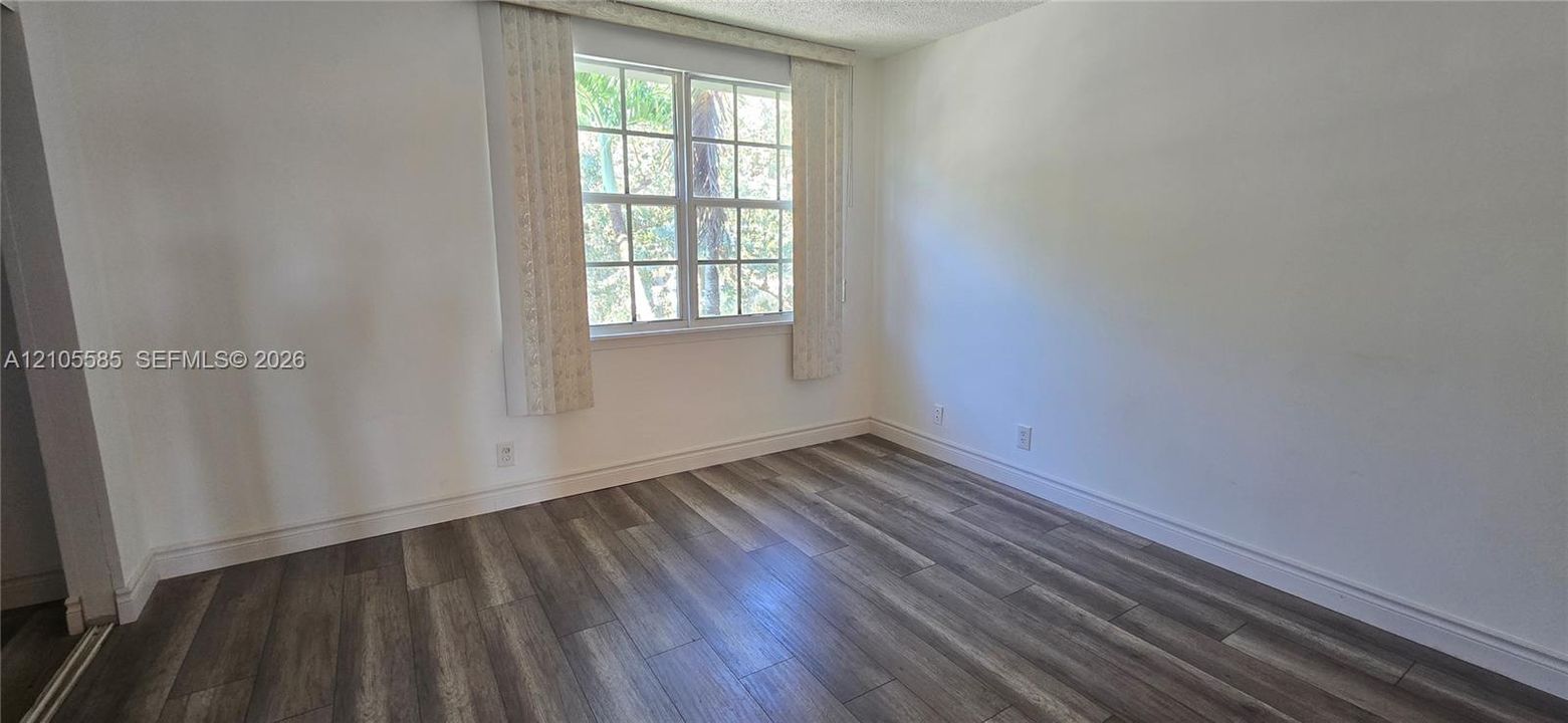 Room featuring wood-finish flooring and a multi-pane window