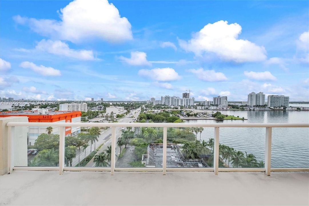 Expansive balcony with glass panel railing and water frontage