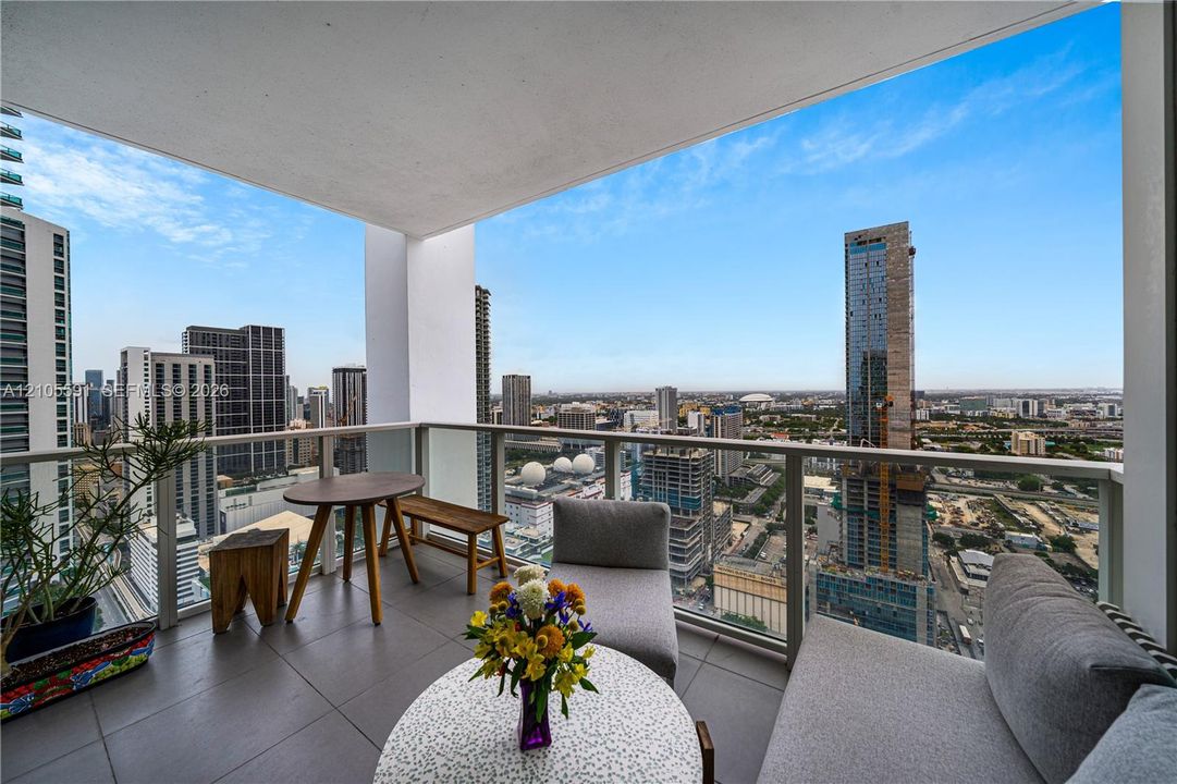 Expansive private balcony with a durable tile surface and glass railing