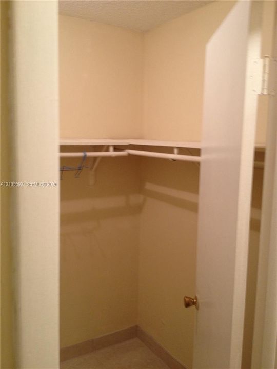 Walk-in closet featuring multi-level shelving, hanging rods, and light-toned wall paint