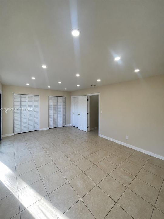 Recessed lighting, tile flooring, louvered bi-fold closet doors, and painted walls