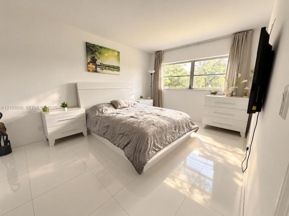 Large-format porcelain tile flooring and a wide, multi-pane window allowing natural light
