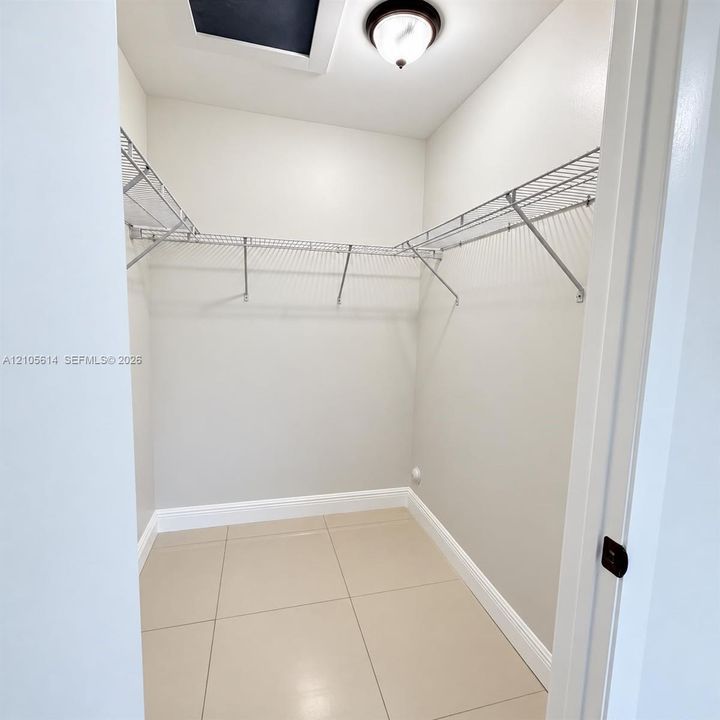 Storage area featuring large-format ceramic tile flooring and multi-level wire shelving
