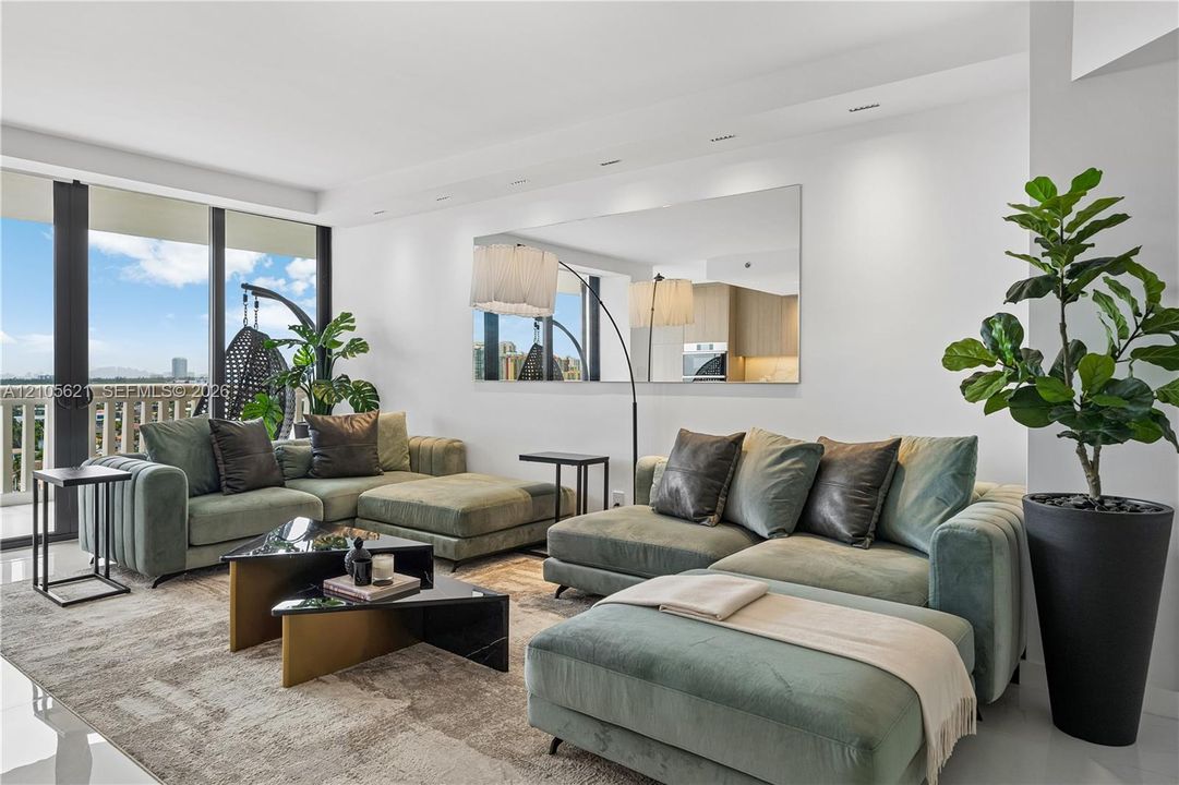 Living area featuring floor-to-ceiling glass sliding doors, large-format polished flooring, recessed ceiling lighting, and a wall-mounted rectangular mirror
