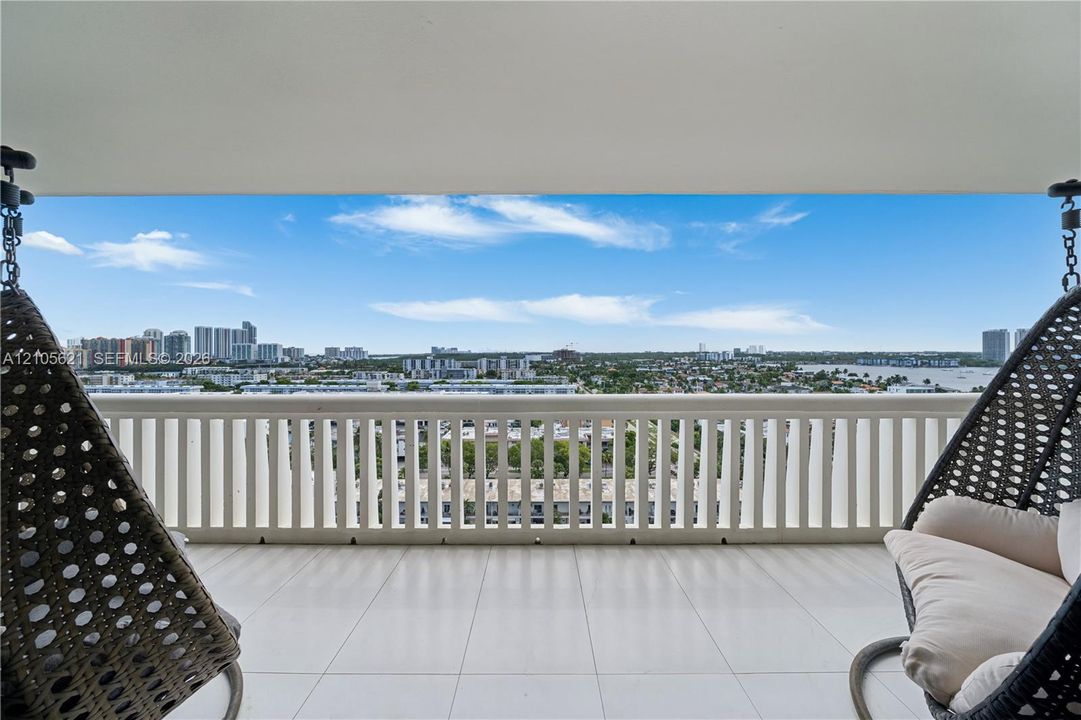 Covered terrace featuring large-format tile flooring and a vertical-slat balcony railing