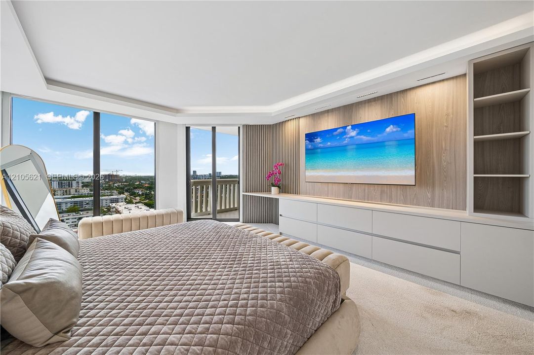 Floor-to-ceiling windows, custom built-in cabinetry with integrated shelving, wood-finish wall paneling, and access to an exterior balcony