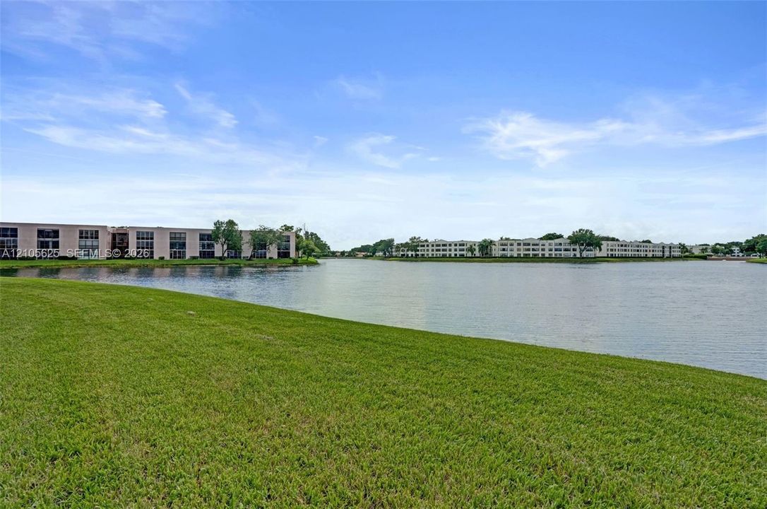 Expansive waterfront grounds featuring a manicured lawn and a wide water basin