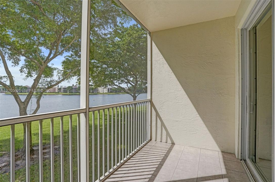 Screened balcony featuring tile flooring, aluminum railing, and water frontage