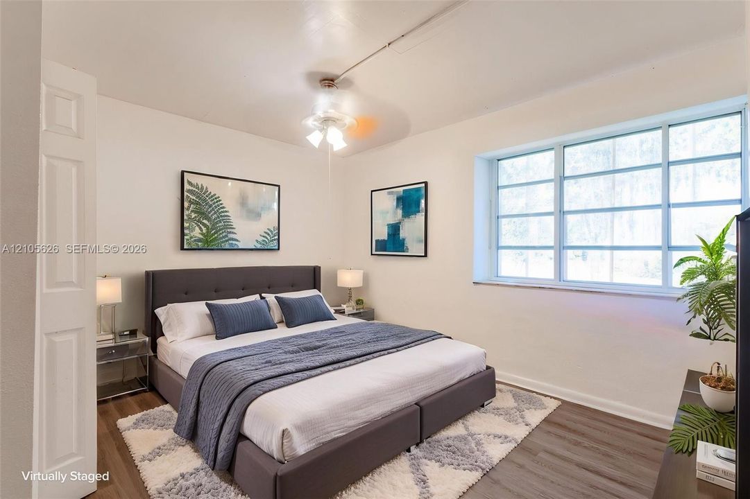 Multi-pane window, wood-finish flooring, and ceiling fan with integrated lighting