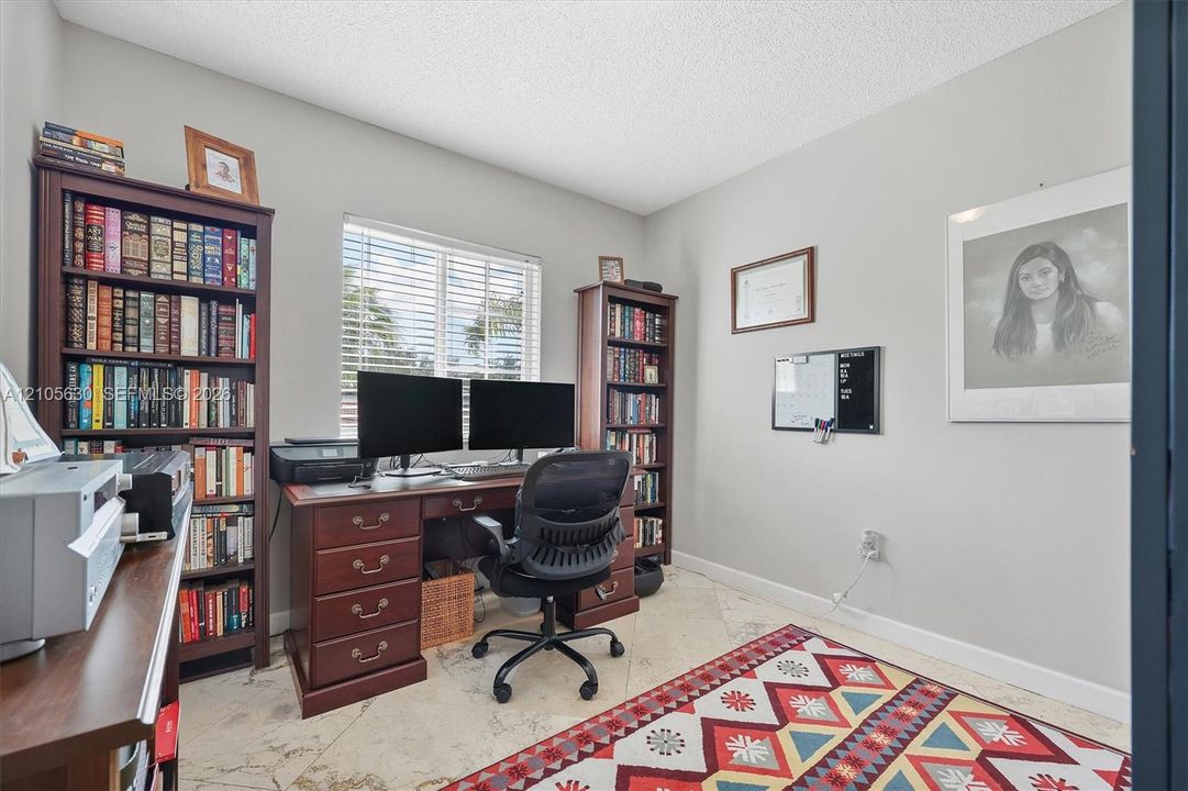 Interior room featuring neutral wall paint, tile flooring, and a window with horizontal blinds