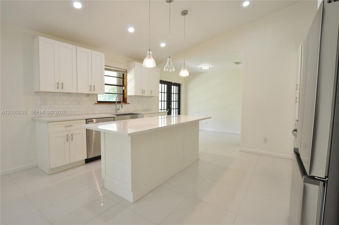 Kitchen featuring white cabinetry, quartz countertops, a central island, recessed lighting, and stainless steel appliances