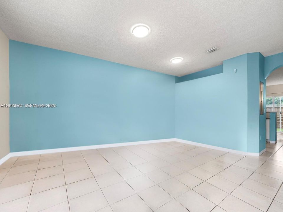 Interior space featuring large-format ceramic tile flooring, neutral wall paint, and recessed ceiling lighting