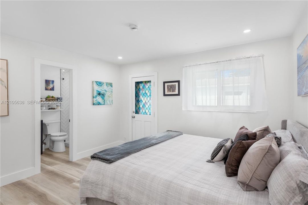 Wood-finish flooring, recessed lighting, and a door featuring decorative leaded glass inserts