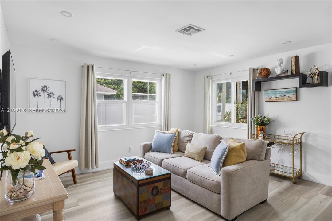 Living space featuring wood-finish flooring, recessed lighting, and dual windows with grid detailing