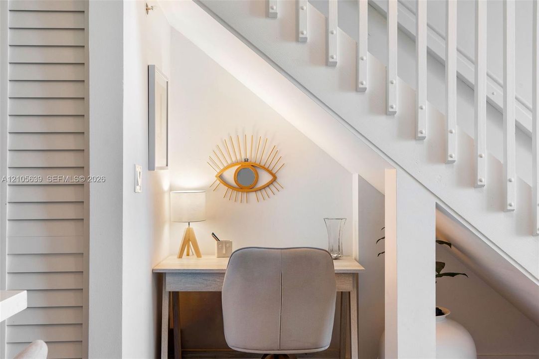 Staircase featuring white balusters and a dedicated recessed alcove area